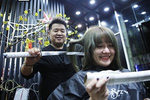 Kỷ lục gia Nguyễn Hoàng Hưng biểu diễn cắt tóc bằng hai thanh kiếm Nhật. Ảnh: Nguyễn Đông.