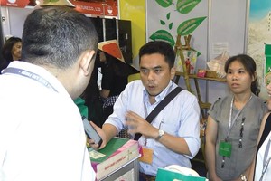 Ông Phạm Minh Thiện tại gian hàng của Công ty TNHH Cỏ May ở Hội chợ xuất khẩu ASEAN - Ấn Độ 2017. Ảnh: Minh Đông