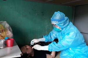 Cán bộ y tế lấy mẫu xét nghiệm cho trường hợp có tiếp xúc gần với bệnh nhân Covid-19.