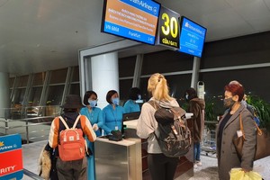 Các hành khách làm thủ tục để lên chuyến bay về Đức vào sáng 8/4.