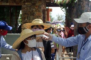 Đo thân nhiệt cho du khác. Ảnh: Xuân Triệu