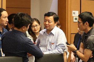 Bộ trưởng Bộ Tài nguyên và Môi trường Trần Hồng Hà trao đổi với báo chí bên hàng lang Quốc hội.