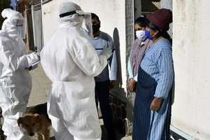 Nhân viên y tế đến từng nhà dân để kiểm tra những người có khả năng nhiễm nCoV tại El Alto, Bolivia hôm 4/7. Ảnh: AFP.
