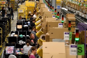 Nhân viên đóng gói hàng hóa cho khách hàng tại trung tâm dịch vụ của Amazon. (Ảnh: AFP/TTXVN)