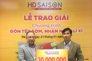 Khách hàng Phùng Đức Linh (phải) nhận thưởng.