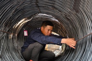 Ngày 16-3, giá thép cuộn bán ra 11,8 triệu đồng/tấn vào đầu giờ sáng, lên 12 triệu đồng/tấn vào buổi trưa và lên 12,5 triệu đồng/tấn vào đầu giờ chiều. Trong ảnh: nhân viên một cửa hàng thép ở TP.HCM treo nhãn hàng phân loại thép cuộn - Ảnh: Ảnh: H.Khoa