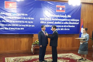 Thừa ủy quyền của Chủ tịch nước CHDCND Lào, Phó Thủ tướng Chính phủ Lào Xomxavat Lengxavath trao tặng cho Bộ trưởng Bùi Quang Vinh Huân chương Isala hạng Nhất