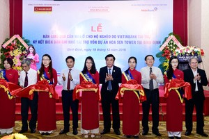 Các đại biểu thực hiện nghi thức cắt băng bàn giao 200 căn nhà ở cho hộ nghèo.