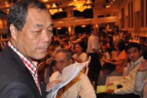 Ông Trầm Bê đi thu phiếu biểu quyết của cổ đông tại Đại hội cổ đông Sacombank tháng 7/2015, bàn về sáp nhập với Ngân hàng Phương Nam.. Ảnh: Lệ Chi