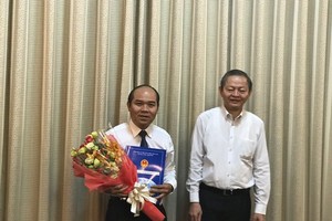 Ông Lê Văn Khoa trao quyết định và chúc mừng ông Trần Văn Bảy.