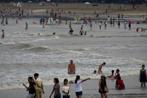 Hàng nghìn du khách tắm biển, bất chấp cảnh báo bão