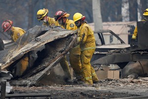 Lực lượng tìm kiếm người sống sót trong vụ cháy rừng Camp ở California hôm 13/11. Ảnh: AP.