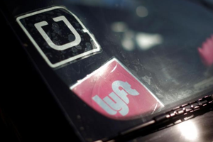 Logo của Uber và Lyft trên một xe hơi tại Mỹ. Ảnh: Reuters.