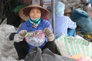 Bà Nguyễn Thị Hồng Thắm cầm một vỏ túi kẹo có xuất xứ từ Mỹ. Ảnh: Guardian.