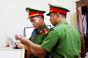 Cảnh sát kiểm tra hóa đơn, sổ sách tại công ty của bà Hậu. Ảnh: C.A