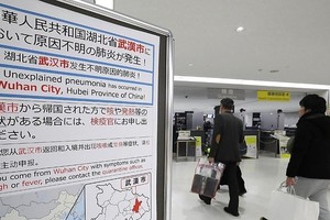 Bảng thông báo về lưu ý biểu hiện bất thường đối với hành khách đến từ Vũ Hán (Trung Quốc) tại sân bay Narita (Nhật Bản). Ảnh: AFP.