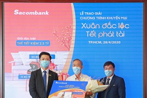  Ông Nguyễn Minh Tâm – Phó tổng giám đốc Sacombank (bên trái) trao sổ tiết kiệm trị giá 2,5 tỷ đồng cho khách hàng Hà Văn Thường (giữa), người may mắn trúng giải đặc biệt chương trình khuyến mãi “Xuân đắc lộc – Tết phát tài”.