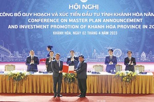 Bộ trưởng Bộ Kế hoạch và Đầu tư Nguyễn Chí Dũng (bên phải) trao Quyết định phê duyệt Quy hoạch tỉnh Khánh Hòa thời kỳ 2021 - 2030, tầm nhìn đến 2050 cho ông Nguyễn Hải Ninh, Bí thư Tỉnh ủy Khánh Hòa dưới sự chứng kiến của Thủ tướng Chính phủ Phạm Minh Chính Ảnh: Nhiệt Băng