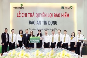 Bà Lê Thị Huệ Anh - Giám đốc Vietcombank Vinh (thứ 7 từ phải sang) trao quyền lợi bảo hiểm nhân thọ Bảo an Tín dụng cho người thụ hưởng Trần Thị Mai Phương (Ảnh: Nguyễn Văn Thắng)