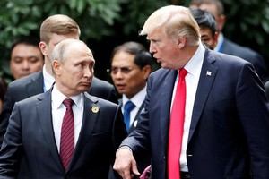 Tổng thống Mỹ Donald Trump và người đồng cấp Nga Vladimir Putin trò chuyện trên đường tới nơi tổ chức buổi chụp hình chung giữa các lãnh đạo tham dự APEC tại Đà Nẵng. Ảnh: Reuters
