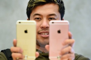 Khách hàng vui mừng sau khi mua chiếc iPhone 6s trong ngày mở bán đầu tiên ở Tokyo, Nhật Bản ngày 25/9/2015. (Nguồn: AFP).