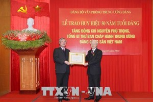 Thay mặt Bộ Chính trị, Ban Bí thư, đồng chí Trần Quốc Vượng trao Huy hiệu 50 năm tuổi Đảng tặng đồng chí Nguyễn Phú Trọng, Tổng Bí thư Ban Chấp hành Trung ương Đảng Cộng sản Việt Nam.