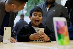 Một cậu bé phấn khích với tính năng aniemoji trên iPhone X. (Nguồn: AFP)