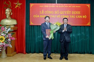 GS.TS. Nguyễn Xuân Thắng (phải) trao quyết định và tặng hoa chúc mừng đồng chí Nguyễn Duy Bắc