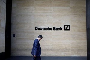 Một người đàn ông đi qua văn phòng của Deutsche Bank ở London. Ảnh: Bloomberg