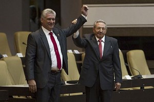 Ông Raul Castro (phải) nắm tay ông Miguel Diaz-Canel sau khi ông này được bầu làm Chủ tịch Cuba. Ảnh: AFP.