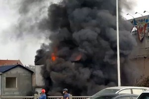 Ngọn lửa kèm theo khói bao trùm ngôi nhà 3 tầng. Ảnh: Văn Vệ