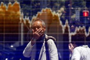 Một người đàn ông nhìn bảng điện tử trên đường phố Tokyo. Ảnh: Reuters.