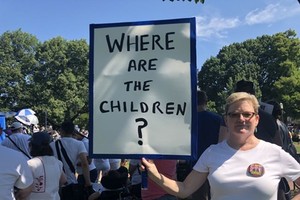 Một phụ nữ tham gia cuộc biểu tình ngày 30/6 ở Washington giơ cao tấm biển với dòng chữ ghi "Những đứa trẻ ở đâu?". Ảnh: CNN.