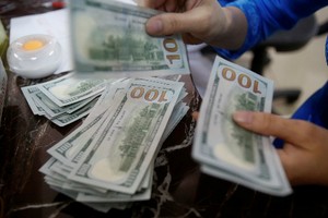 Một nhân viên ngân hàng đếm tiền USD tại Hà Nội. Ảnh: Reuters.