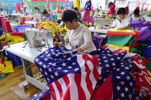 Công nhân Trung Quốc đang may cờ Mỹ tại một nhà máy ở Fuyang thuộc tỉnh An Huy, miền đông Trung Quốc. Ảnh: SCMP.
