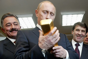 Tổng thống Vladimir Putin kiểm tra một thỏi vàng của Nga hồi năm 2005 (Ảnh: Time).