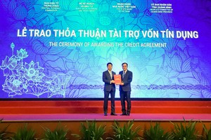 Ông Nghiêm Xuân Thành, Chủ tịch HĐQT Vietcombank (bên trái) trao bản thỏa thuận nguyên tắc thu xếp vốn đối với dự án Nhà máy nhiệt điện Quảng Trạch 1 cho đại diện Tập đoàn Điện lực Việt Nam, ông Dương Quang Thành, Chủ tịch Tập đoàn