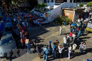 Người dân Venezuela xếp hàng chờ đổi tiền bên ngoài ngân hàng trung ương ở Caracas. (Nguồn: AFP/TTXVN).