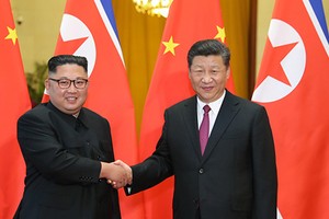 Lãnh đạo Triều Tiên Kim Jong-un bắt tay Chủ tịch Trung Quốc Tập Cận Bình trong lễ đón tiếp ở Đại lễ đường Nhân dân Bắc Kinh ngày 19/6. Ảnh: Xinhua.