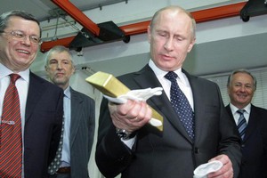 Tổng thống Nga Vladimir Putin cầm trên tay một thỏi vàng (Ảnh: Getty).