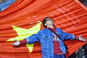Một thanh niên ở Hà Nội ăn mừng sau khi đội tuyển bóng đá Việt Nam giành chiến thắng trước đội Jordan hồi tháng một. Ảnh: Giang Huy.