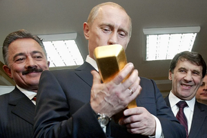 Tổng thống Vladimir Putin kiểm tra một thỏi vàng của Nga hồi năm 2005 (Ảnh: Time).