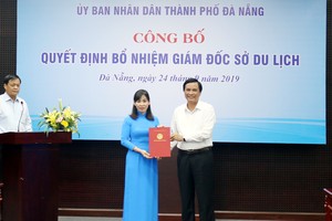 Ông Trần Văn Miên trao quyết định và tặng hoa cho bà Hạnh.