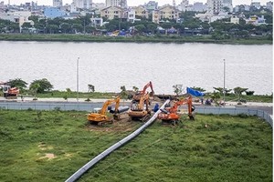 Công nhân thi công kéo đường ống D900 qua sông Hàn. Ảnh: TNG.