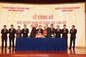 Ông Trần Mạnh Hùng (hàng trên, bên trái) bàn giao nhiệm vụ cho ông Phạm Đức Long. (Nguồn: T.Q/Vietnam+).