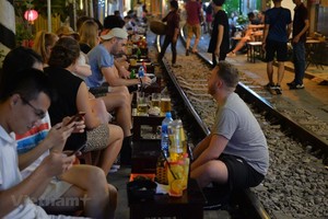 Trước khi bị đóng cửa, nhiều du khách đã đến Phố cà phê đường tàu để trải nghiệm cảm giác ngồi uống nước sát với đoàn tàu chạy qua. (Ảnh: Hoàng Anh/Vietnam+)