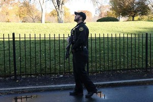 Một đặc vụ thuộc Cơ quan Mật vụ Mỹ quan sát bầu trời trong lúc Nhà Trắng bị phong tỏa hôm nay. Ảnh: Reuters.