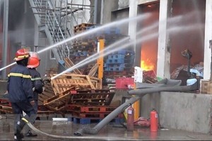 Lực lượng phóng cháy, chữa cháy nỗ lực dập lửa. (Ảnh: Nguyễn Văn Việt/TTXVN)