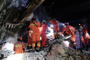 Lực lượng cứu hộ tìm kiếm nạn nhân dưới đống đổ nát của ngôi nhà bị đổ sập sau trận động đất ở tỉnh Tứ Xuyên, Trung Quốc, ngày 18/6/2019. (Ảnh: AFP/TTXVN)