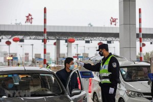 Kiểm tra thân nhiệt của lái xe trên tuyến đường cao tốc ở Vũ Hán, tỉnh Hồ Bắc, Trung Quốc, ngày 24/1. (Ảnh: AFP/TTXVN)
.